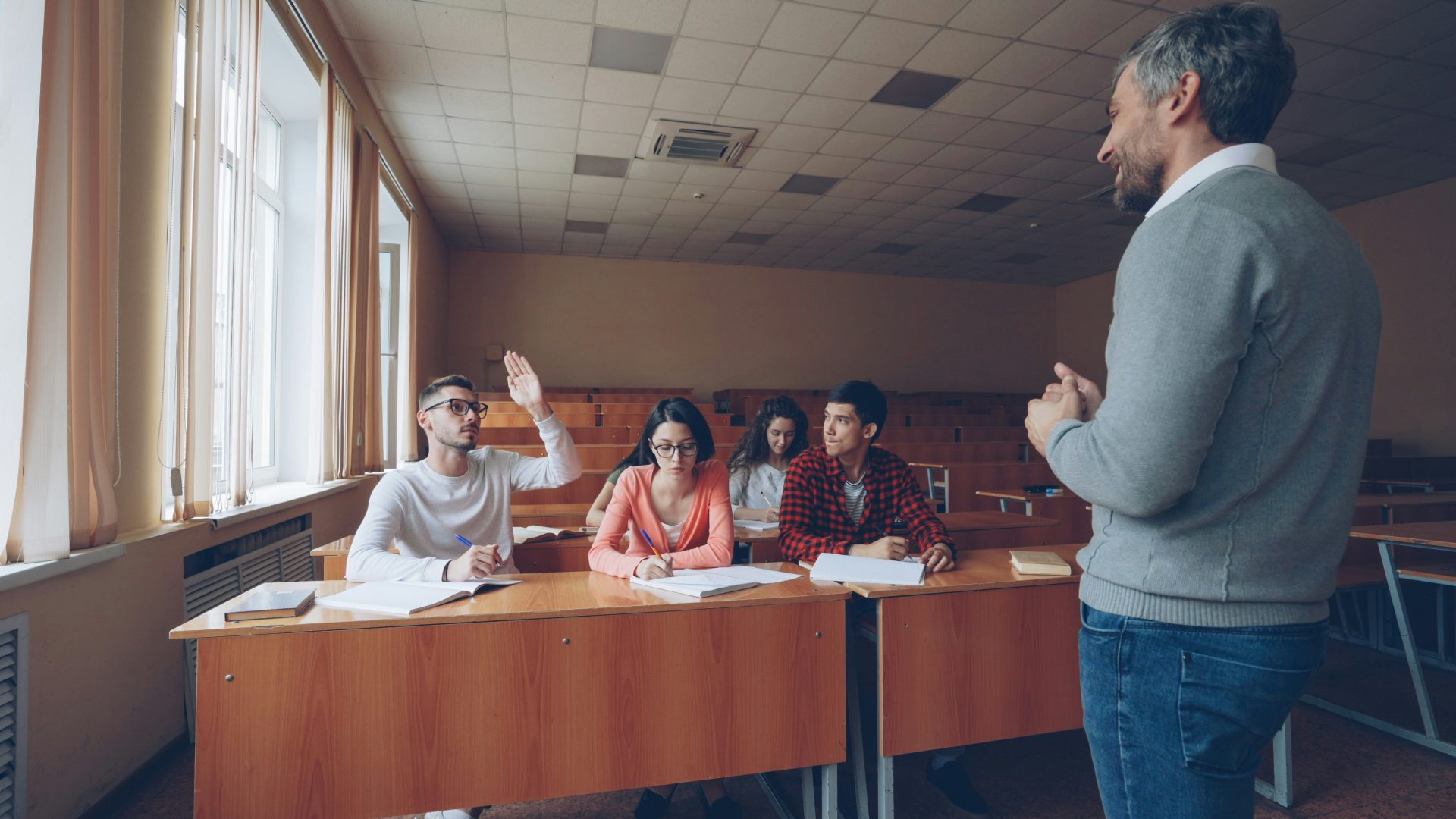 Teacher interacting with students in a classroom setting.