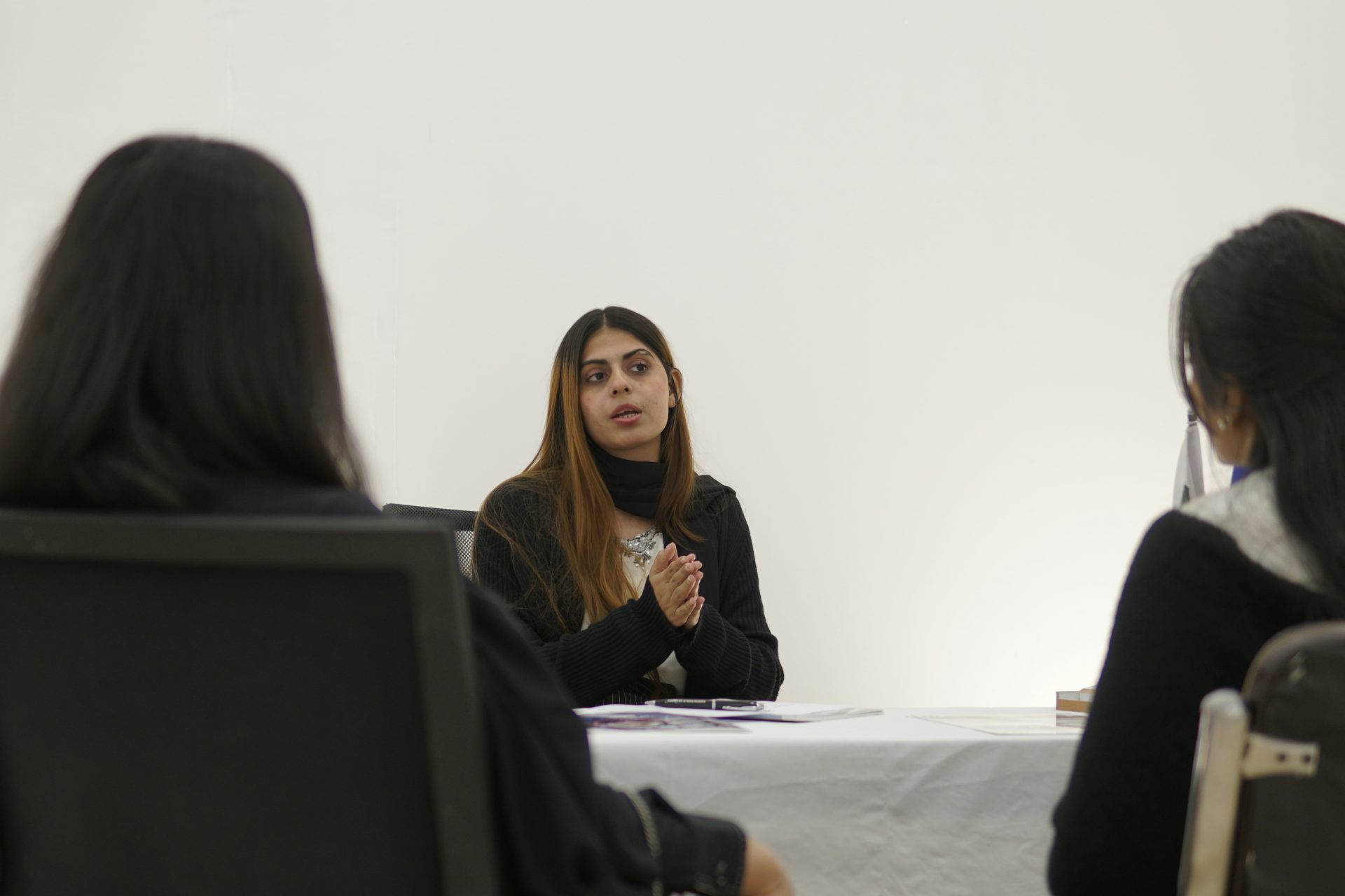 Woman speaking to two people across table