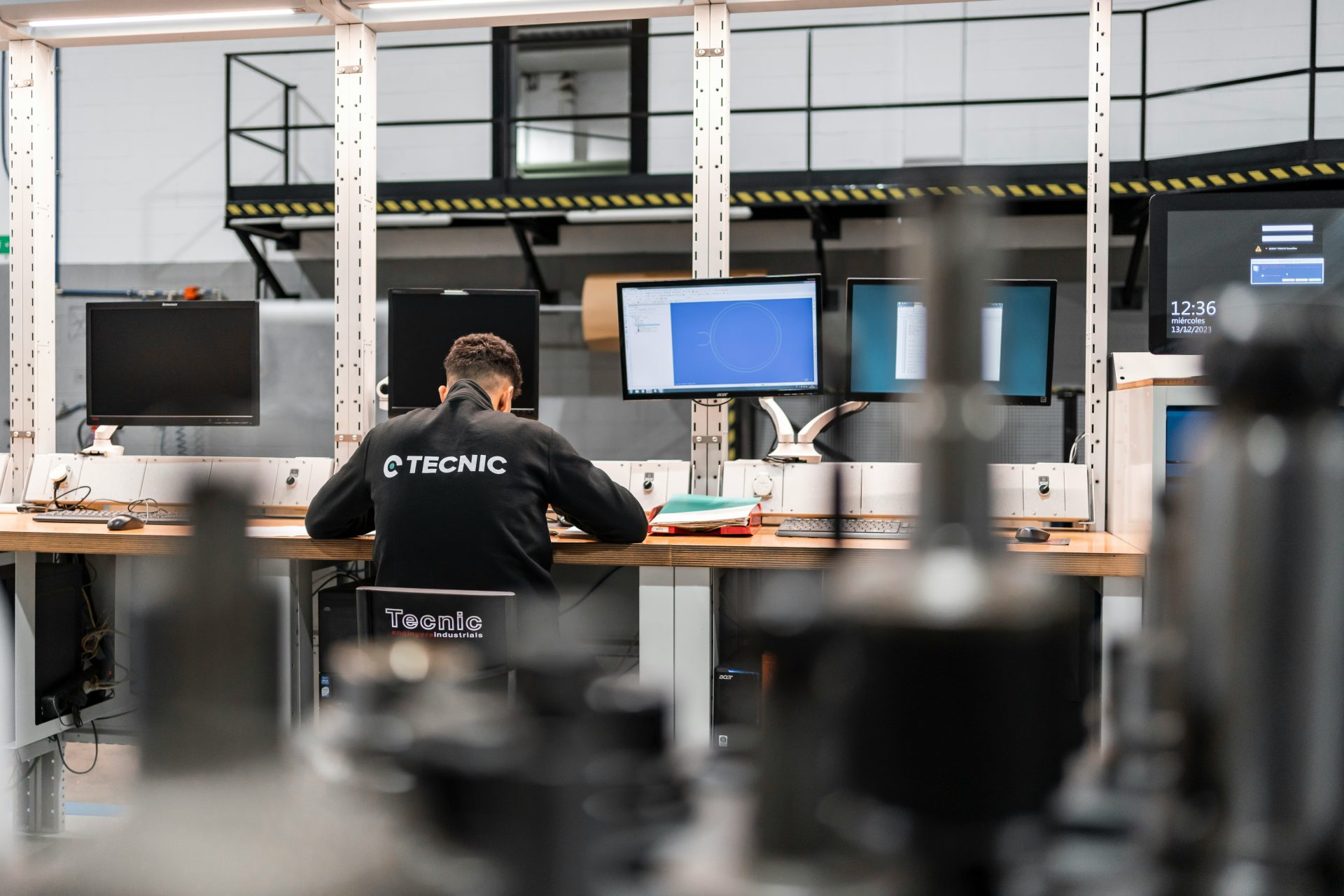 Ein Arbeiter konzentriert sich auf mehrere Computerbildschirme.